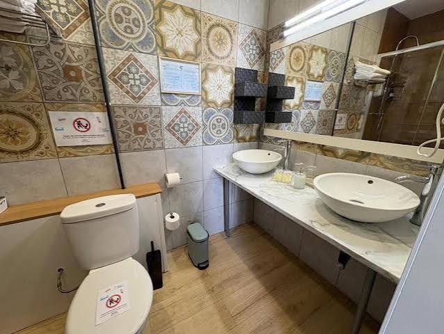 Elegant bathroom in a Quadruple Room at Hotel Ginebra Barcelona, featuring modern fixtures and a clean, refined interior