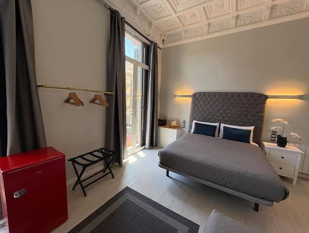 Spacious Quadruple Suite at Hotel Ginebra Barcelona featuring an original ceiling and elegant, comfortable interiors.